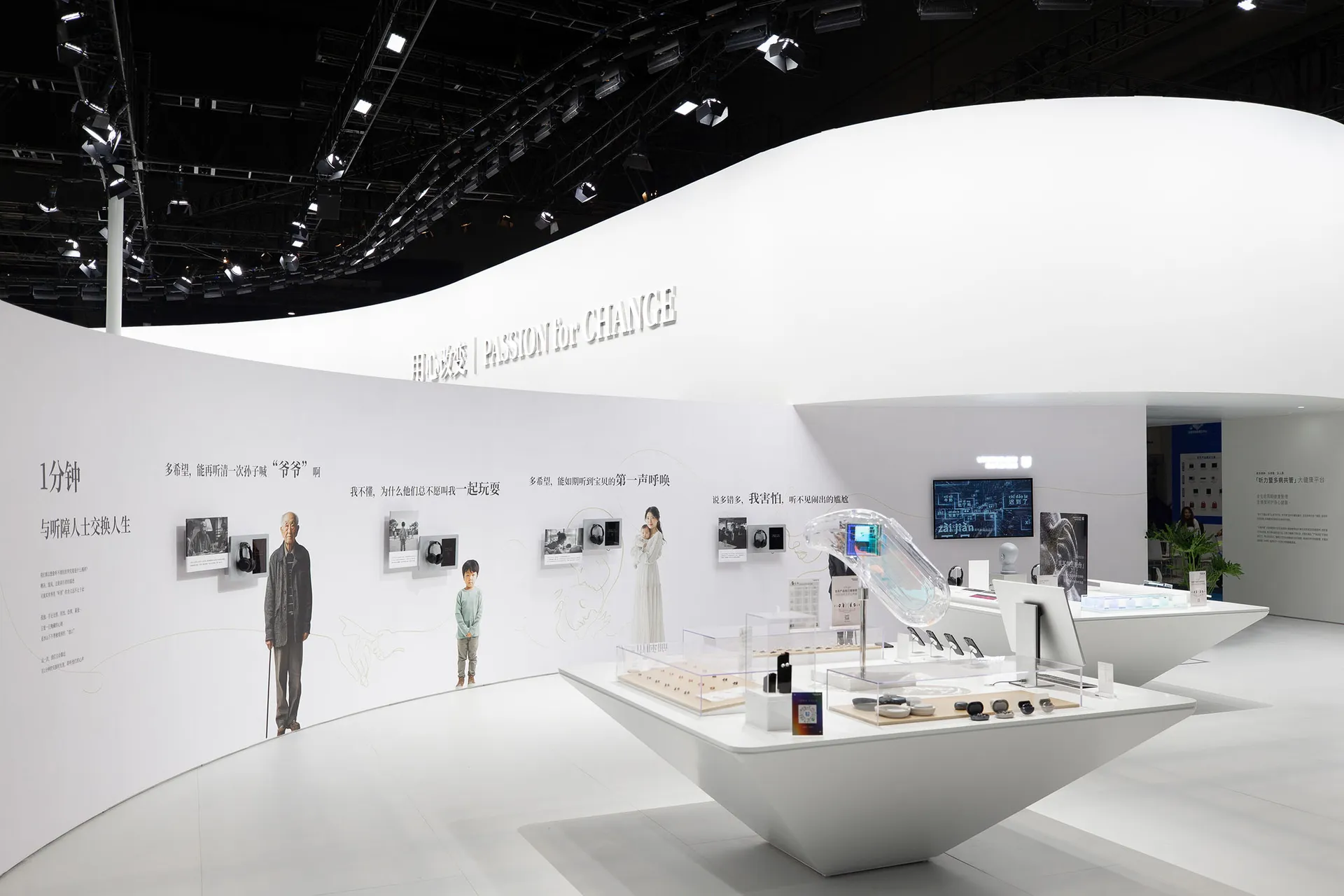 An indoor exhibition space showcasing audio technology products and materials, featuring a white curved wall and a display ta