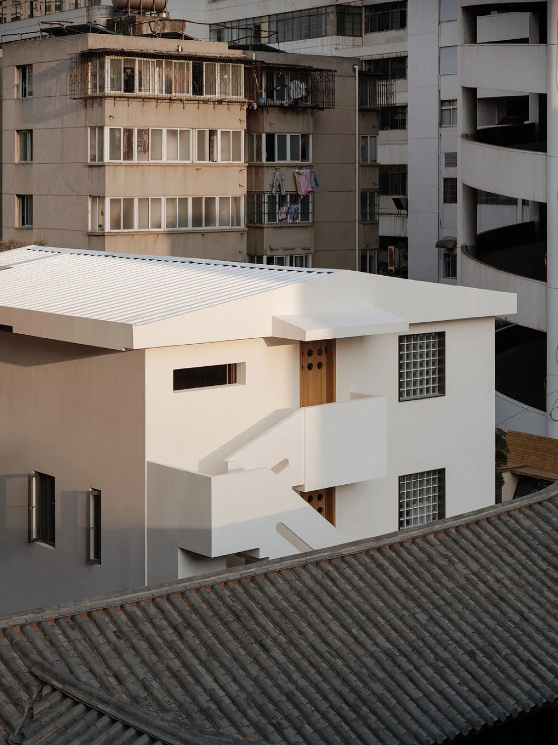 一座現代混凝土建築,採用極簡設計與俐落線條,搭配大面窗戶與平坦屋頂。
