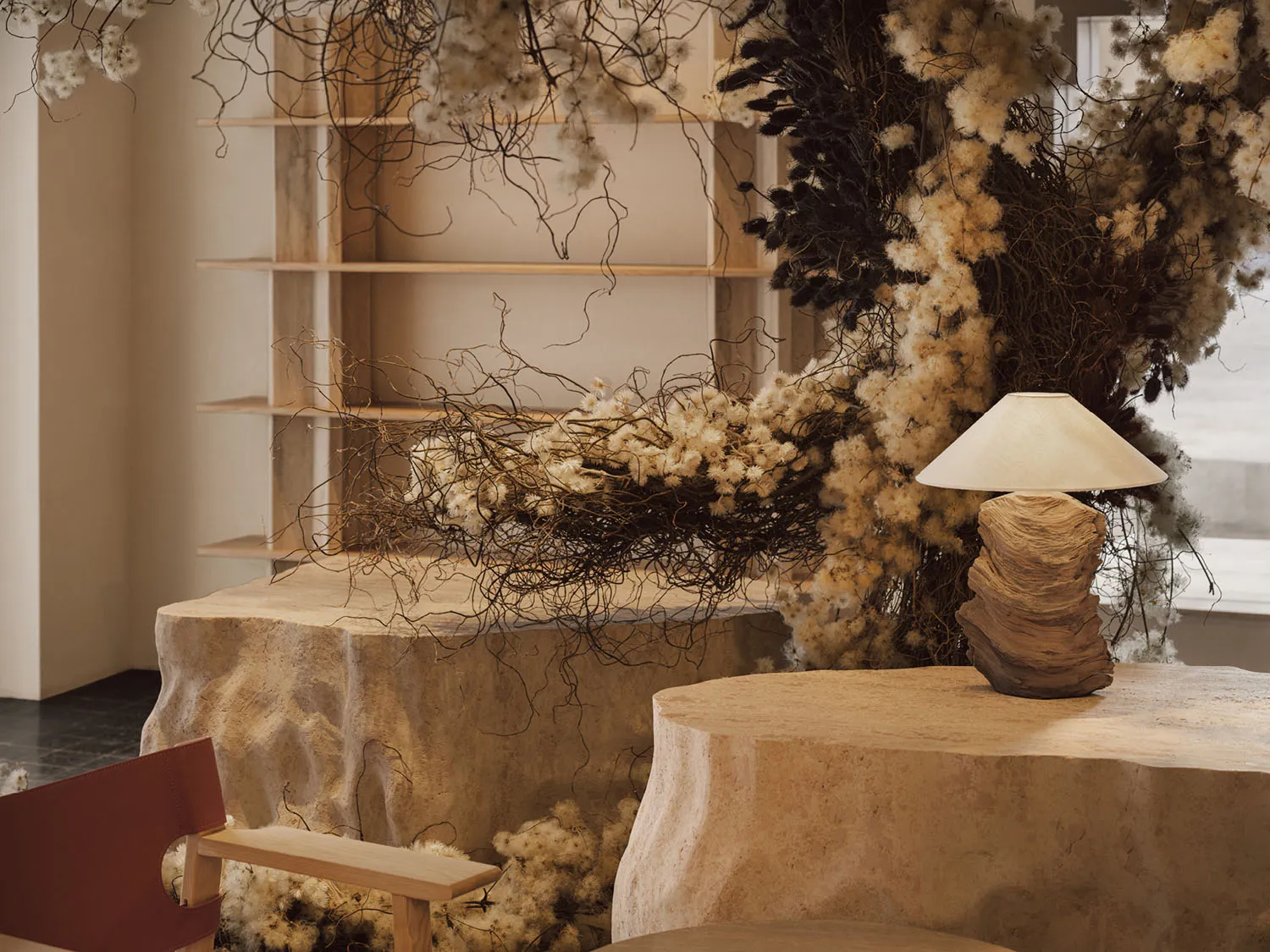A cozy living space featuring natural materials such as wood, stone, and dried flowers.
