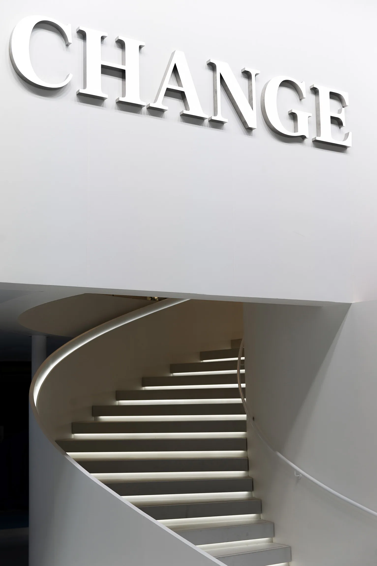 Modern, metallic staircase with illuminated steps and a sleek design.