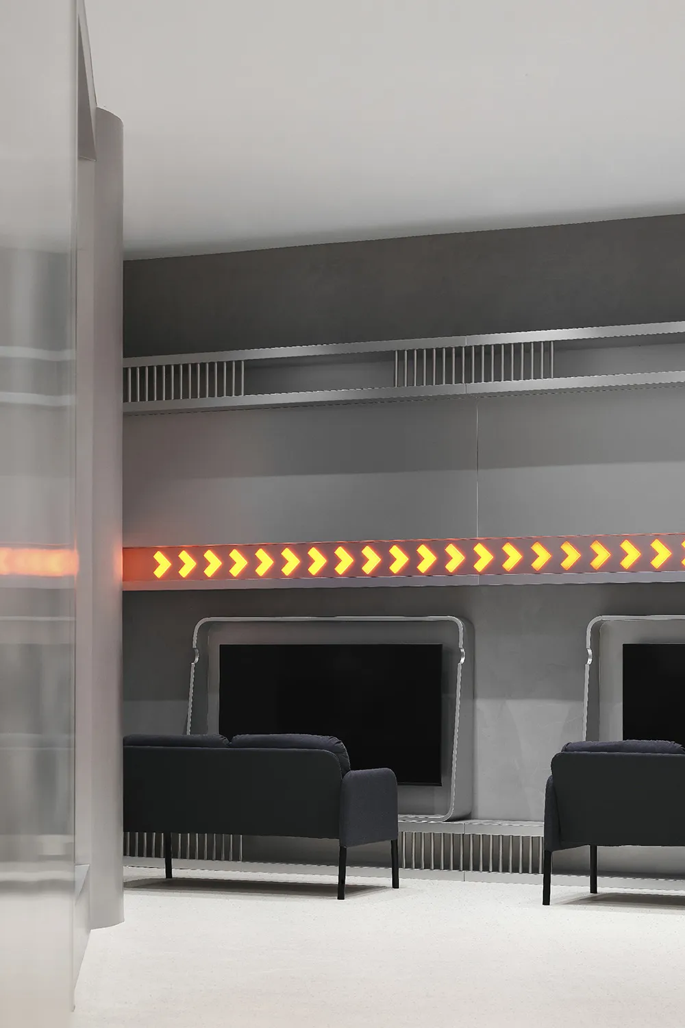 A minimalist office waiting area featuring metallic finishes, a sleek design, and a seating area.