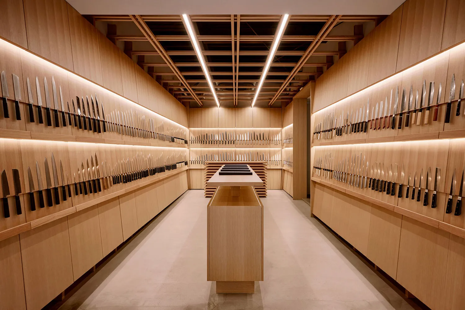 A meticulously organized knife shop featuring a variety of knives mounted on wooden walls.