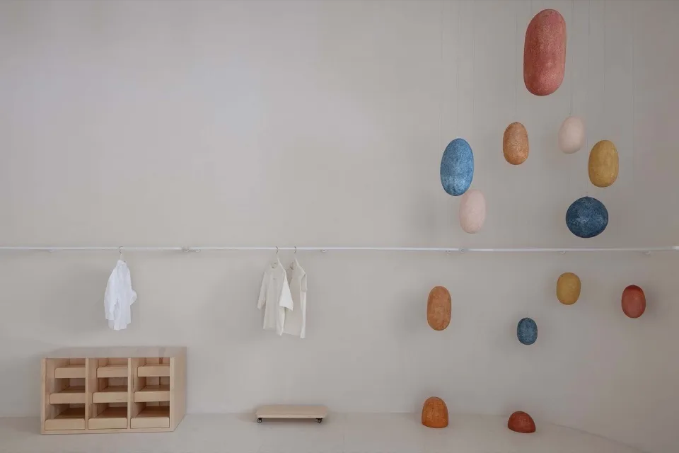 A modern retail storefront with hanging abstract shapes and minimalist furniture.