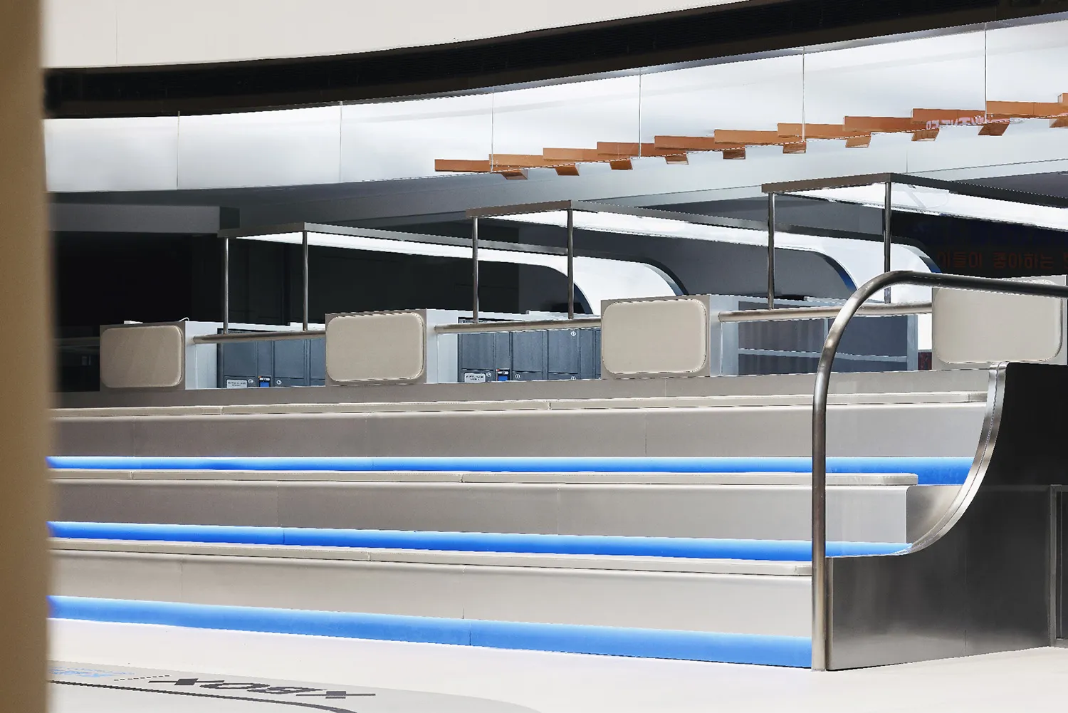 A sleek, metallic bar counter with blue lighting in a modern commercial interior.