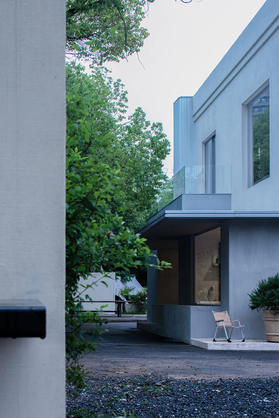 Modern residential exterior featuring a concrete facade and a serene garden setting.