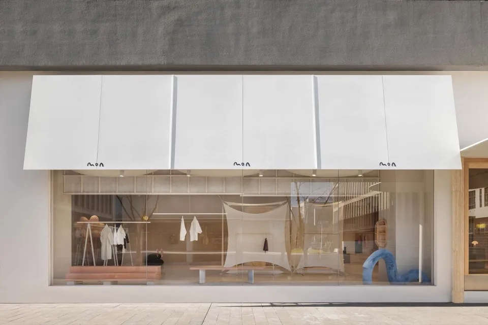 Modern storefront with large glass windows displaying interior retail items.