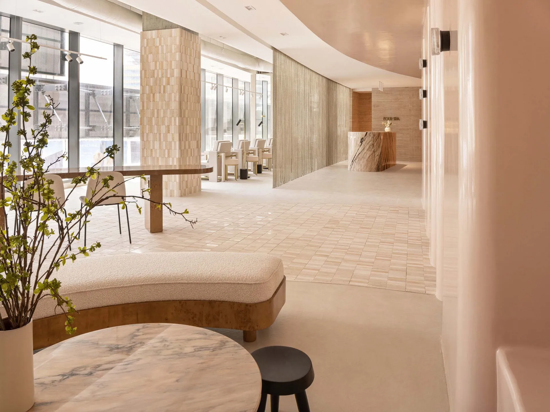 Modern entrance to a spa featuring marble flooring and seating areas.