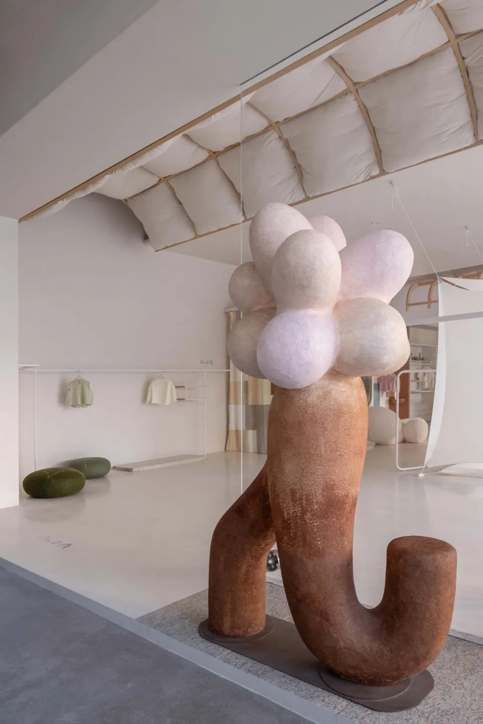 Metal pendant sculpture in a minimalist retail store setting