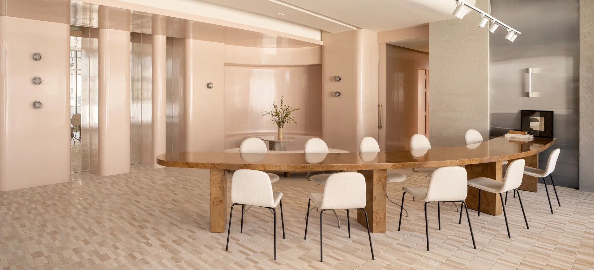 Modern conference room with wooden furniture and white chairs.