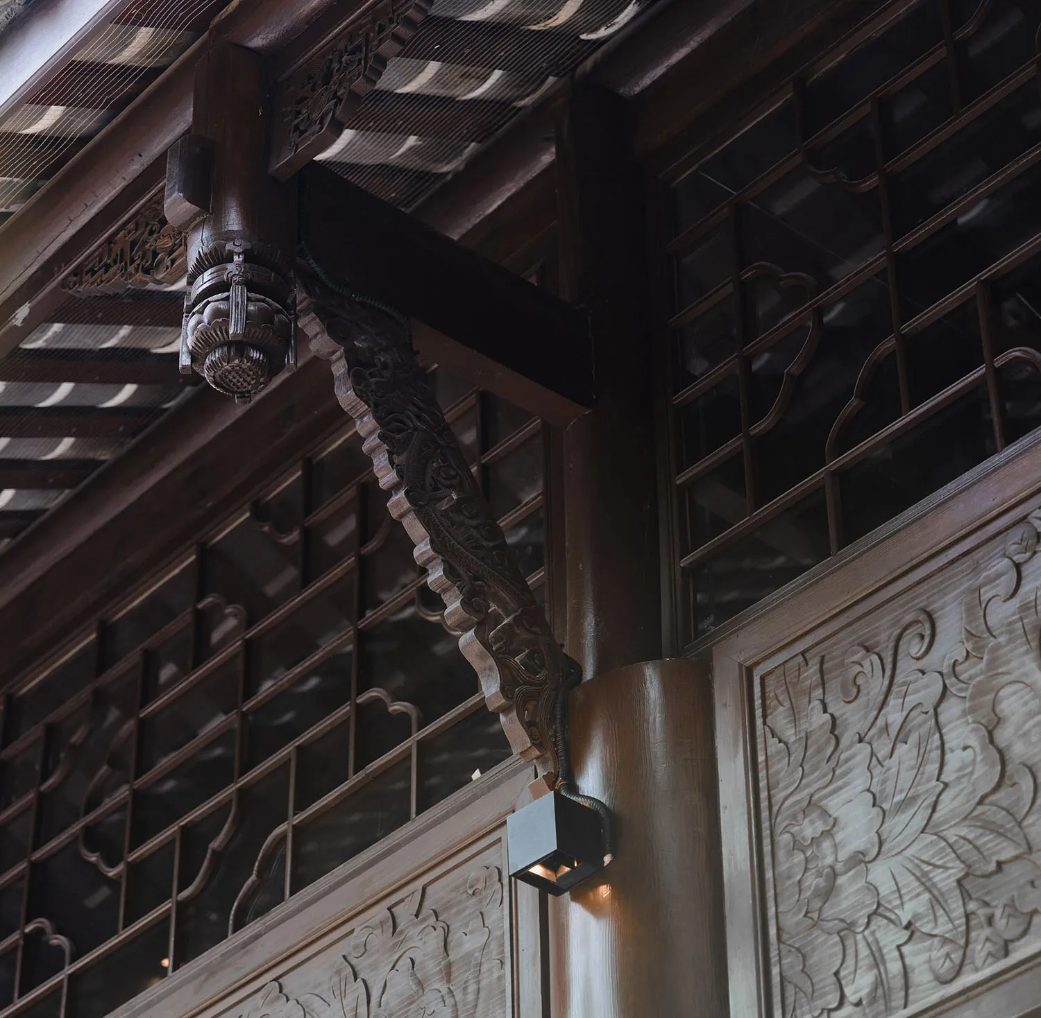 A close-up view of intricately carved wooden panels and beams in a traditional architectural setting.