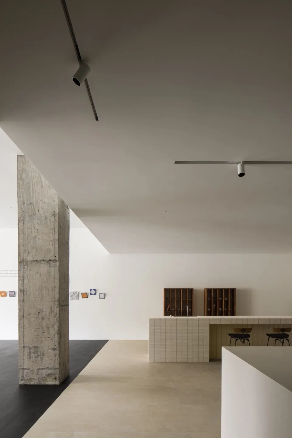 A modern interior space with concrete columns, tiled countertops, and minimalist design elements.