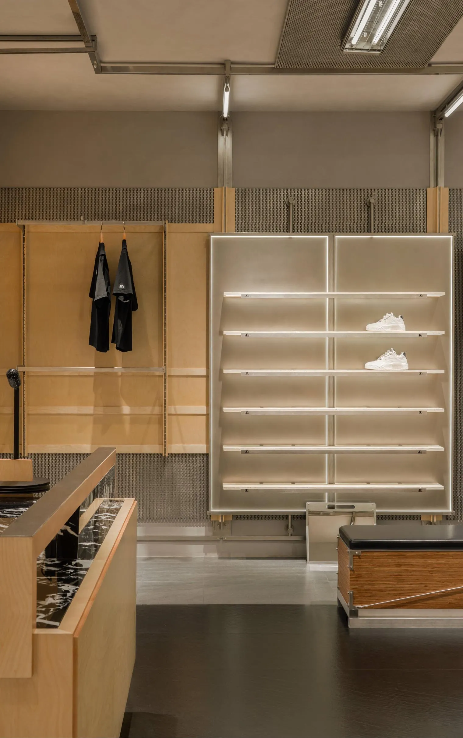 Modern retail shop with wooden shelves displaying white sneakers on the top shelves.