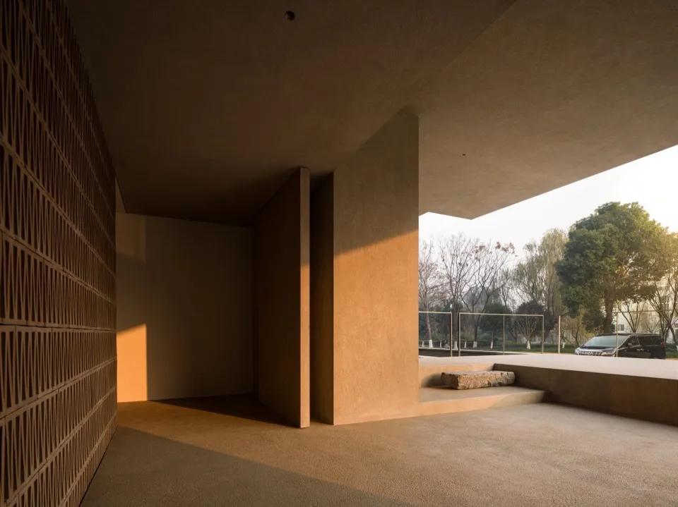 A minimalist building interior featuring concrete columns and a natural light-filled space.