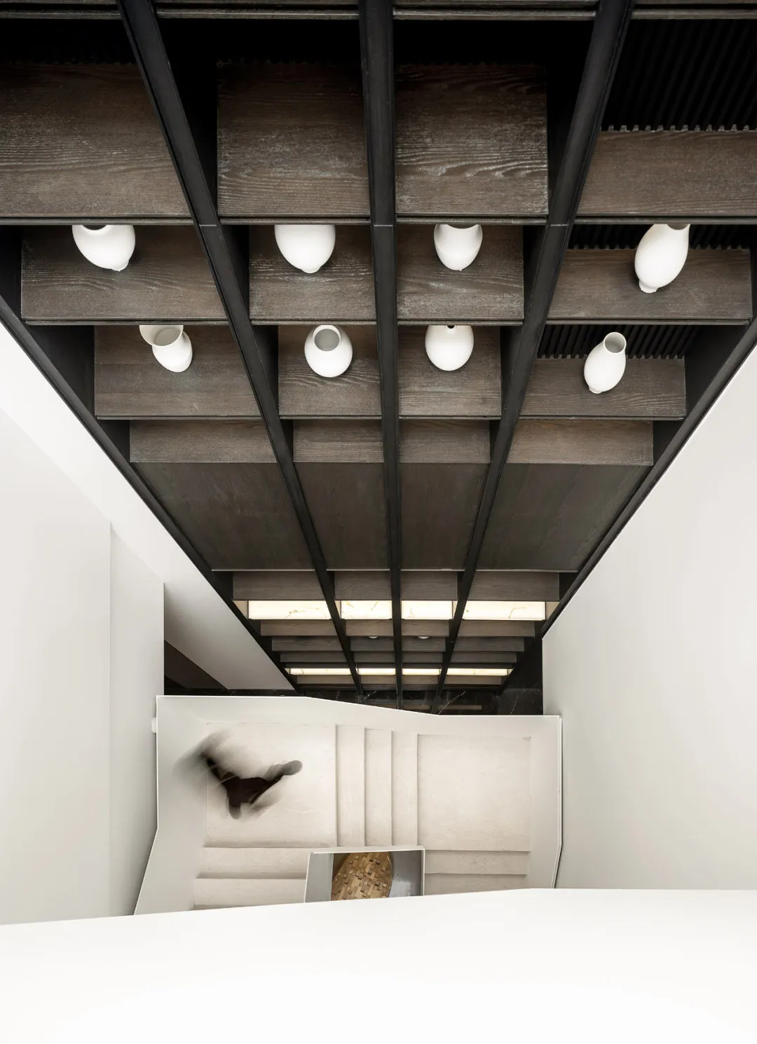 Modern minimalist staircase with wooden steps and metal railings.