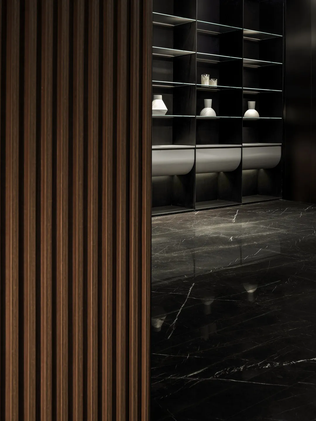 Modern bathroom with a minimalist interior design, featuring sleek marble walls and a dark floor.