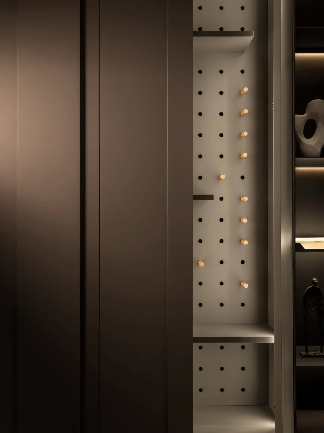 A modern metal pegboard closet storage system with adjustable pegs for organizing clothes and accessories.