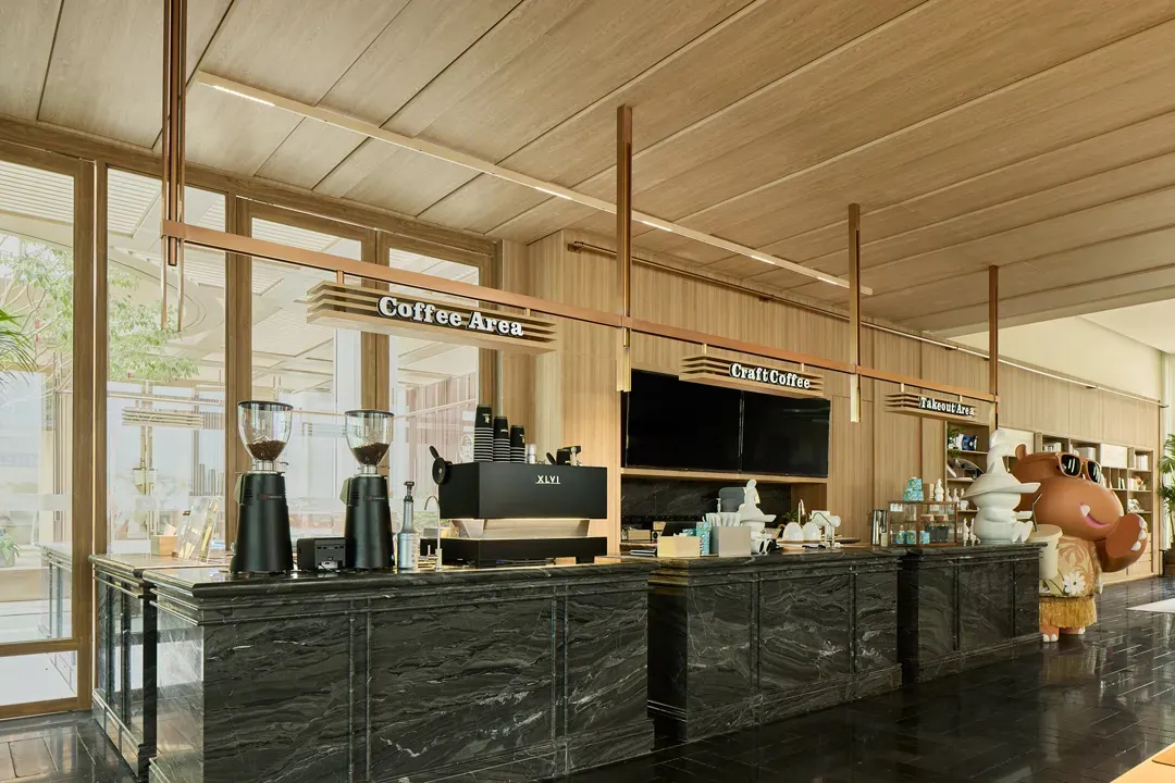 A modern coffee shop featuring marble countertops and wooden accents.