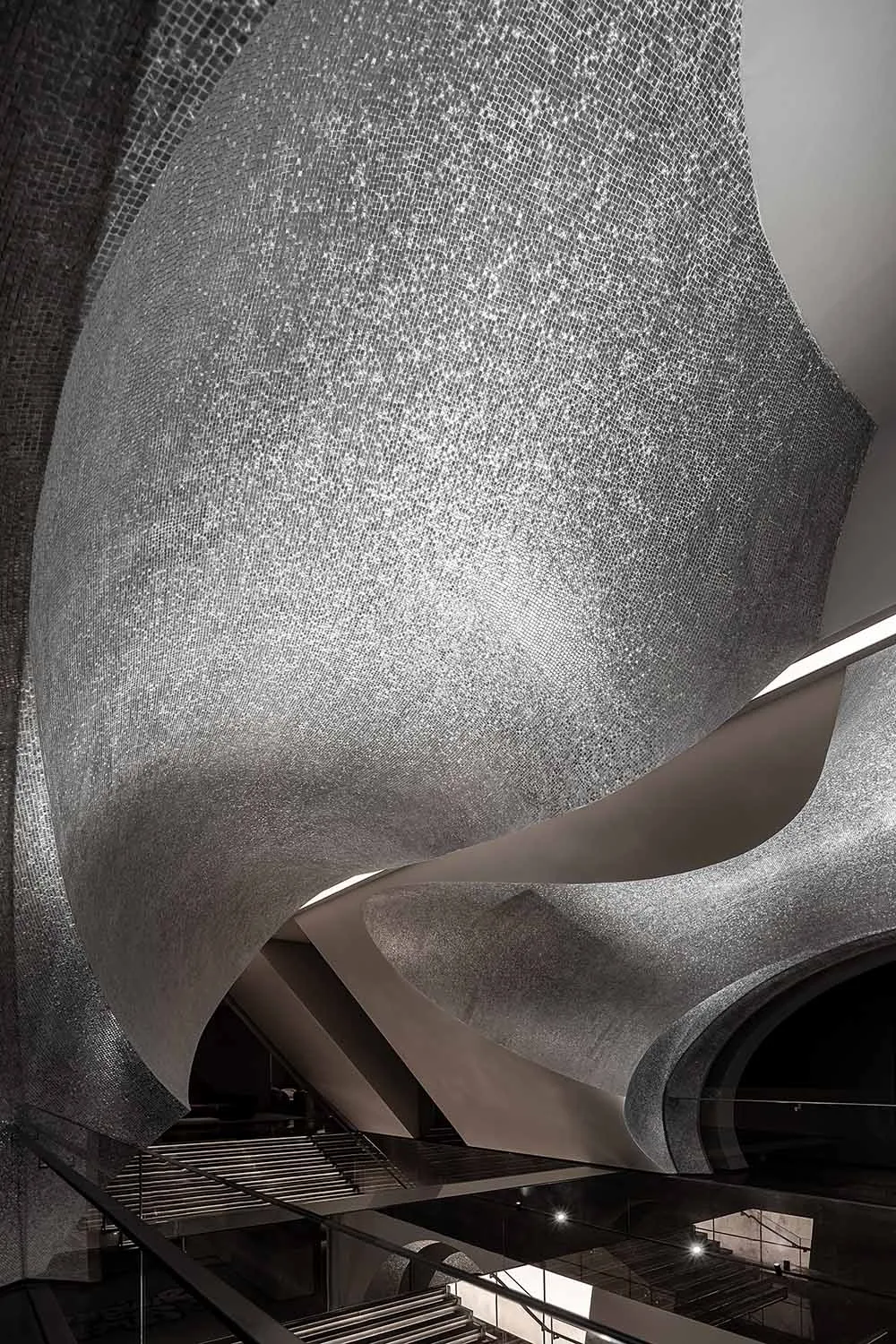 A modern, curved metallic staircase with a sleek, futuristic design