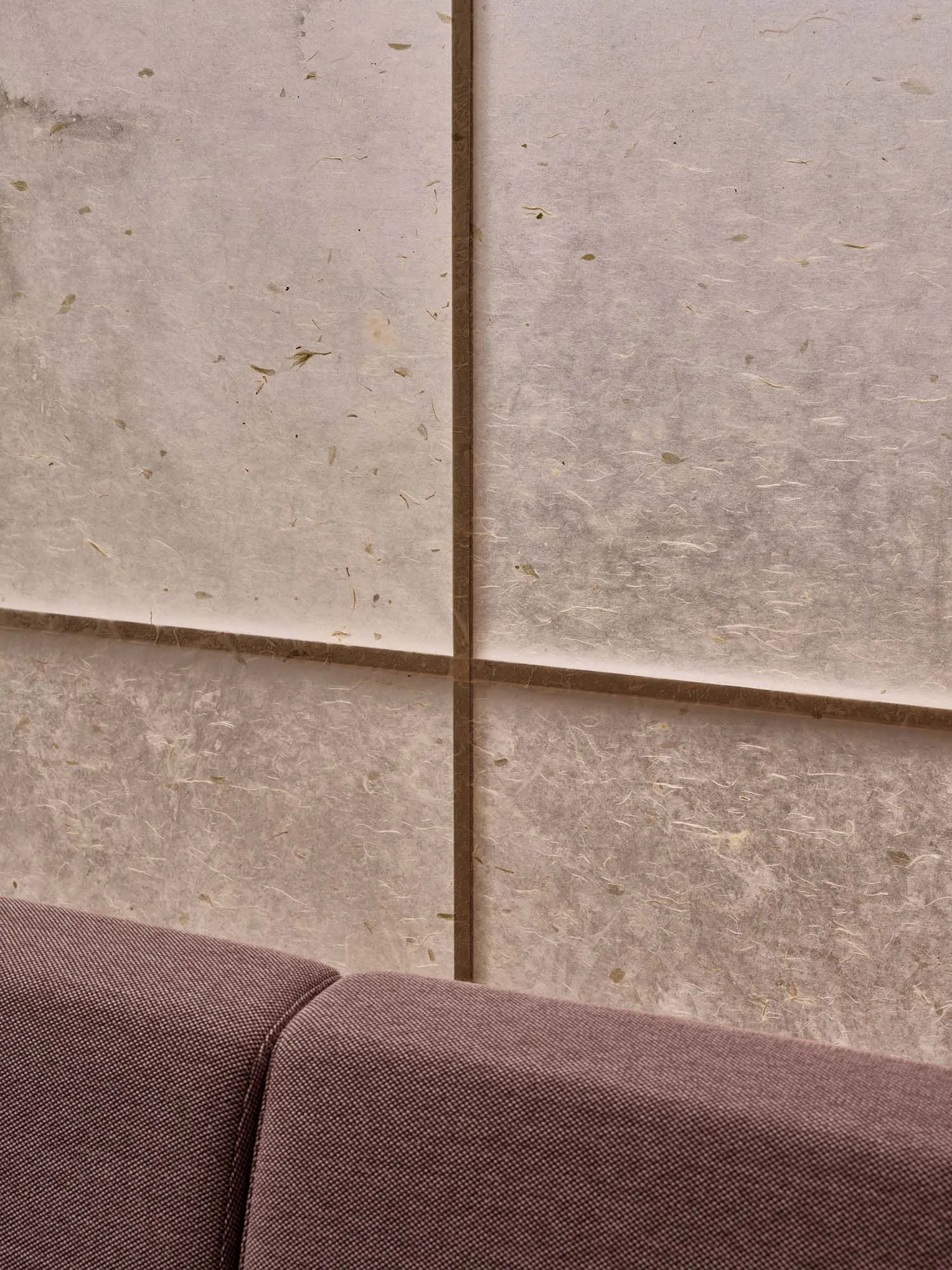 A close-up view of modern interior wall tiles made of paper, showcasing their textured surface and natural fibers.