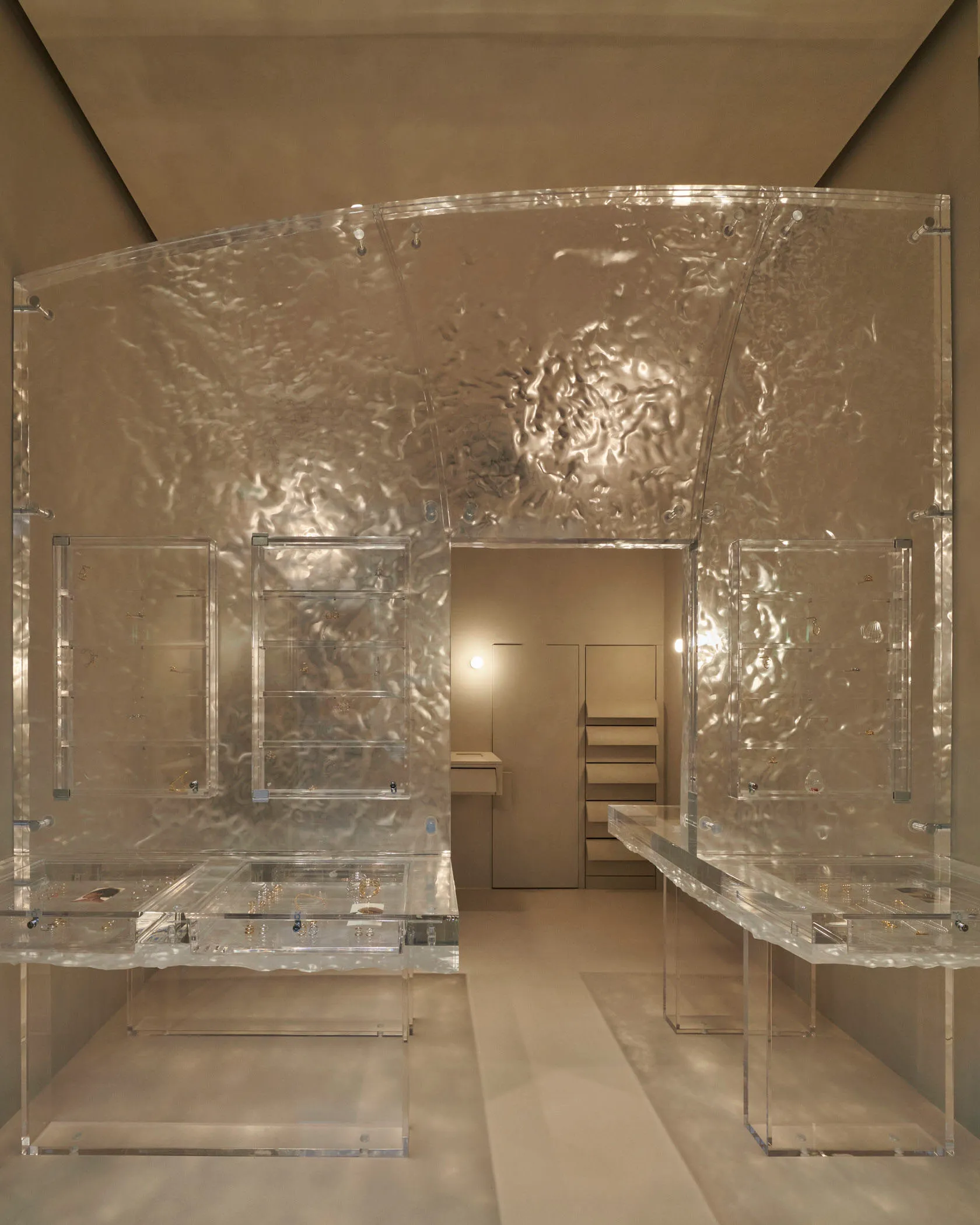 Minimalist jewelry store display with clear glass cases.