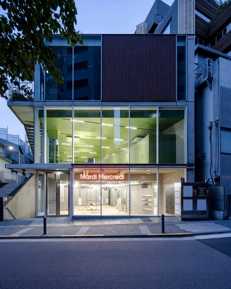 Modern retail storefront with a glass facade, open storefront display, and urban street view.