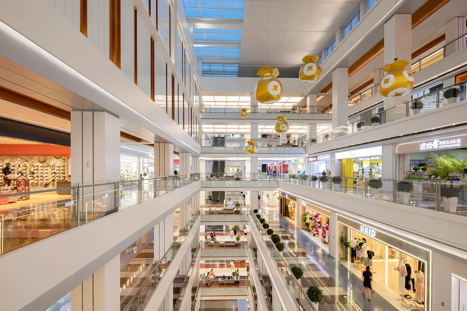 View of a modern shopping center with multiple levels and various retail stores.