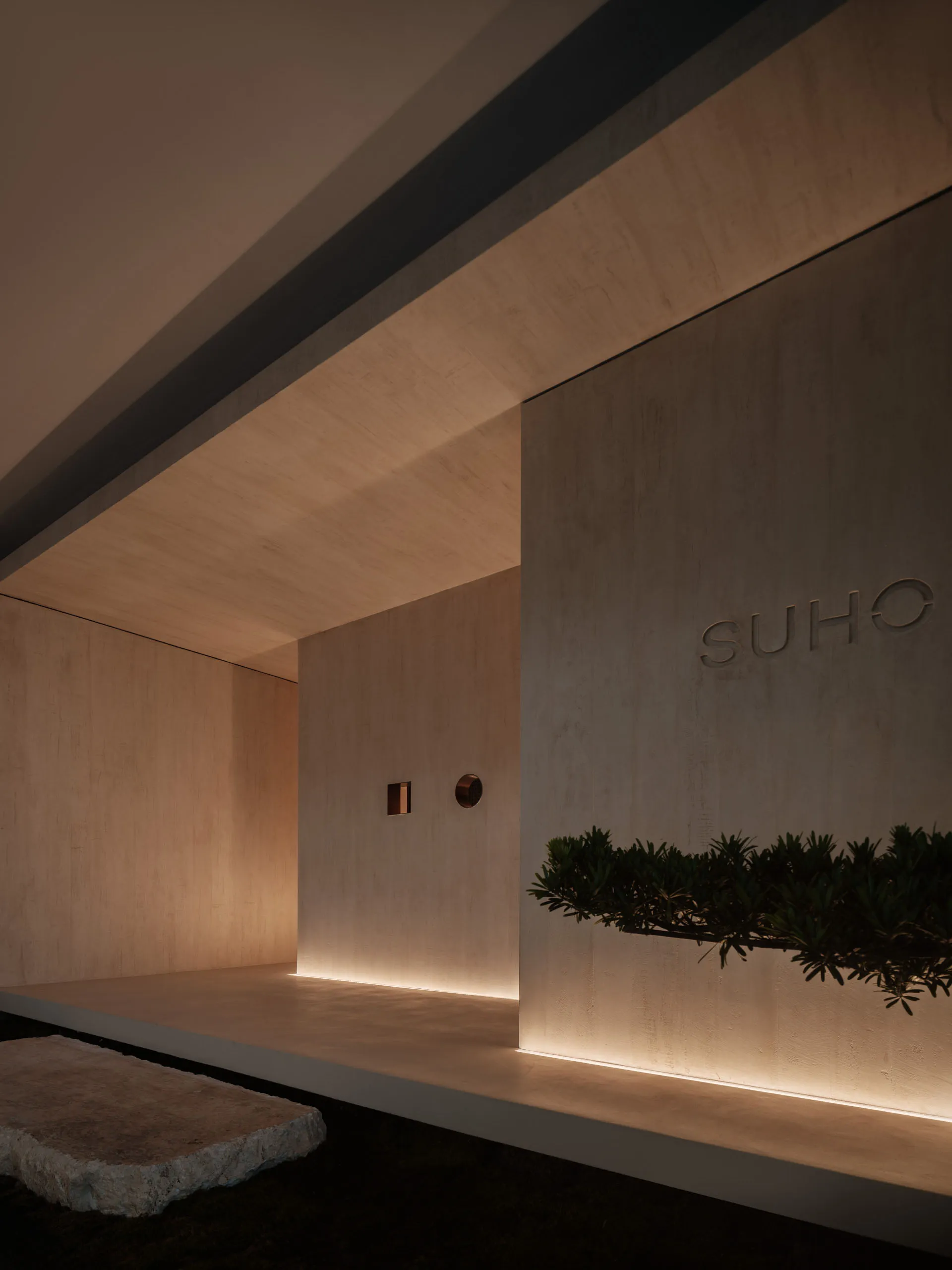 A minimalist interior space featuring concrete walls and warm lighting