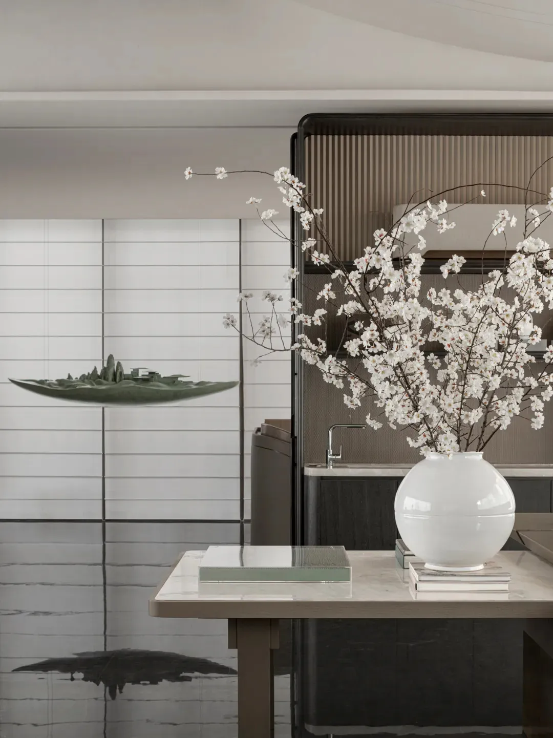 A minimalist interior design featuring a large vase with white flowers on a table.