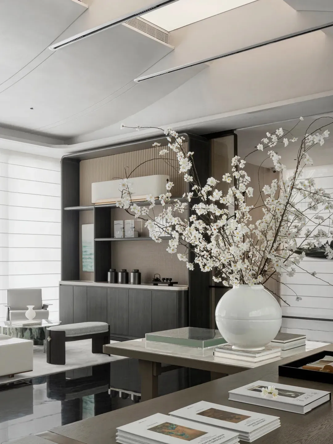 A modern living room featuring marble surfaces, wooden furniture, and metal accents.
