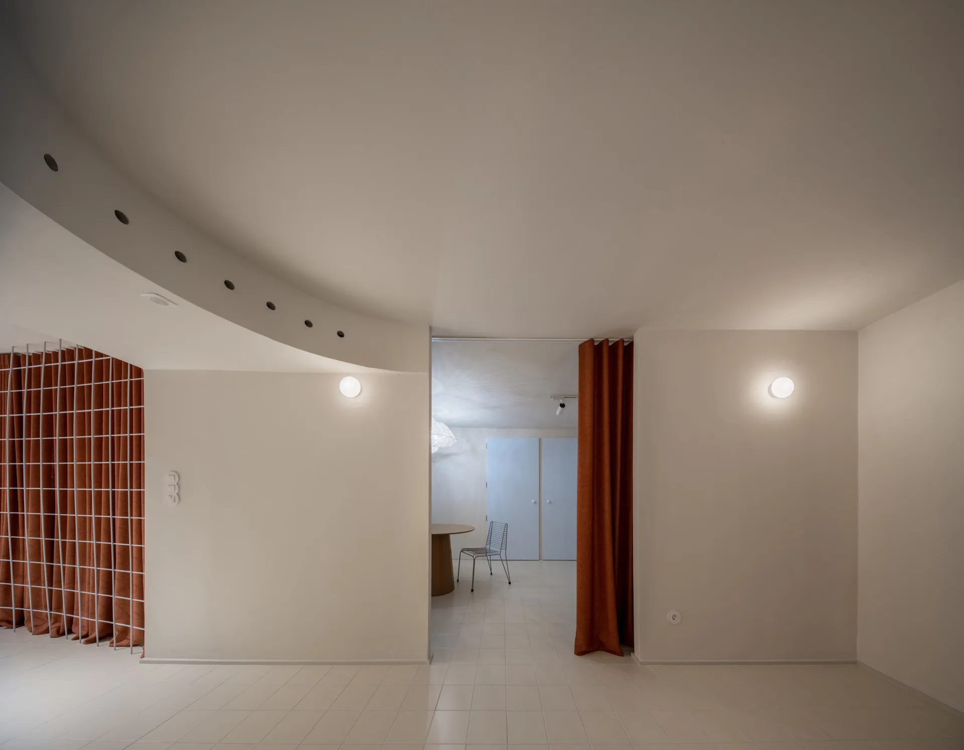 A minimalist, modern apartment interior with a white interior design, featuring a smooth plaster finish on the walls and floo