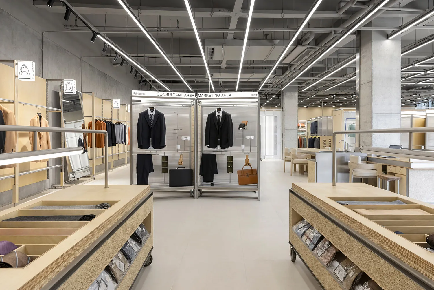 一間專售西裝的現代零售店室內，採用鋼製衣架、玻璃隔板、混凝土地板與木質元素。