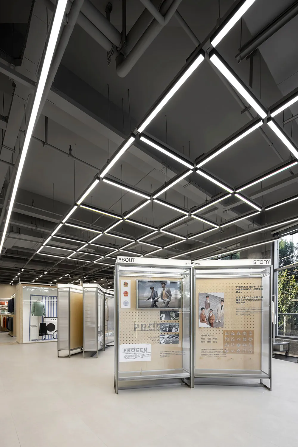 Modern retail space featuring glass and metal structural elements and lighting.