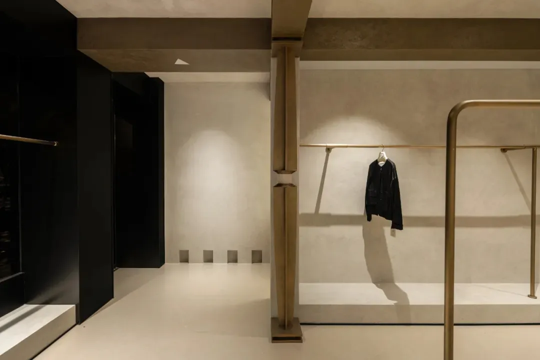 工業風零售空間，展示金屬衣物陳列架