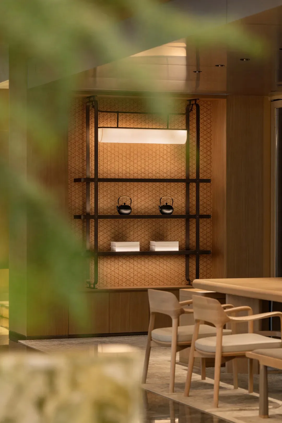 A modern dining room featuring wood shelves with kettles and boxes.