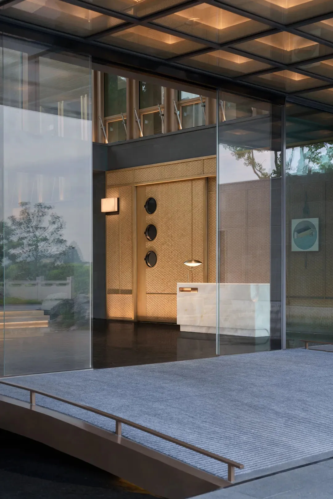 Modern entrance featuring a glass and wooden door with round windows.