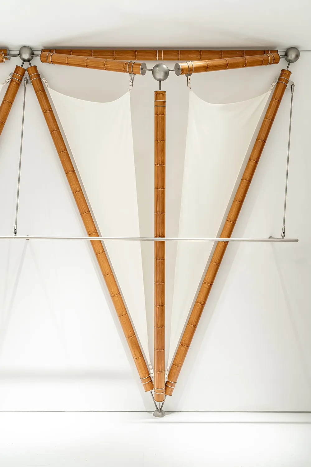 A modern art installation featuring wooden elements hanging from the ceiling.