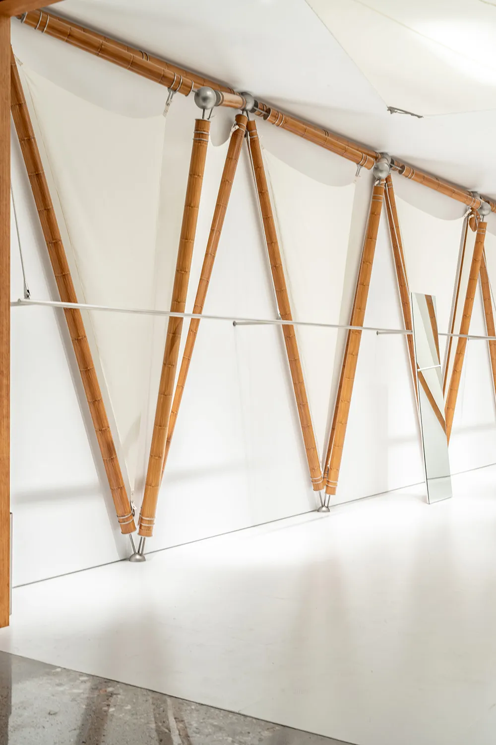 A minimalist interior design featuring wood frames and white textiles.