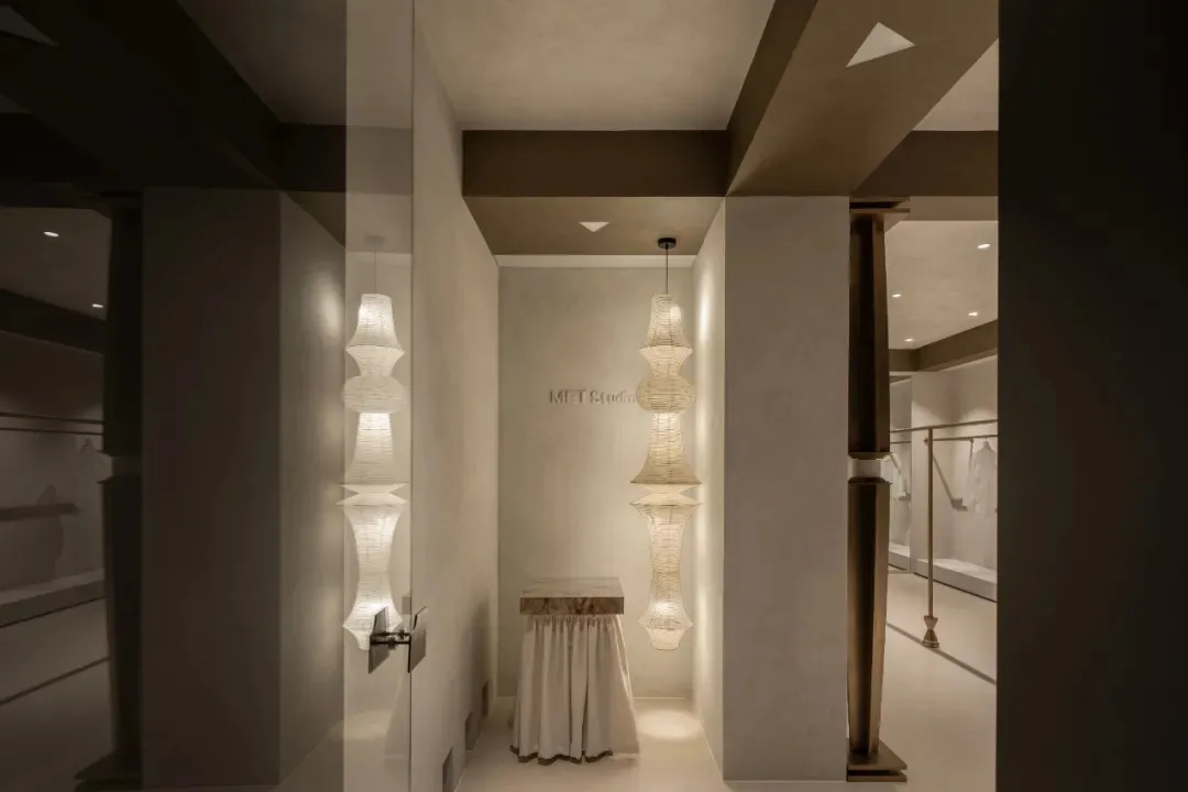 A minimalist modern retail storefront with glass walls and a white interior.