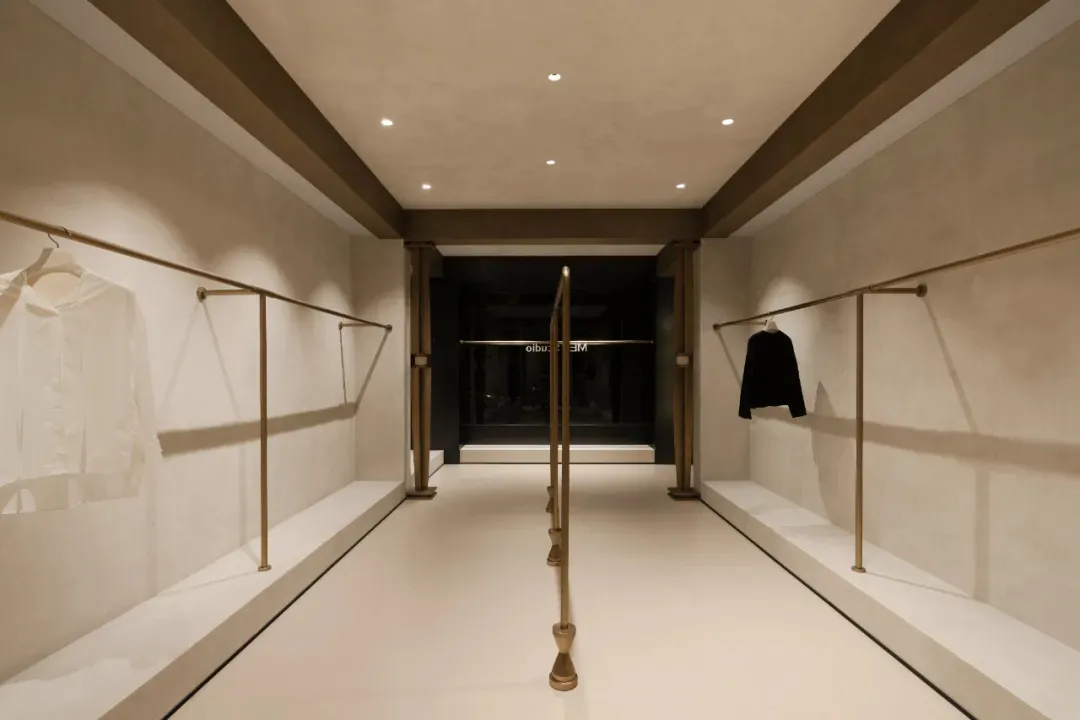 A sleek, modern storefront with a concrete exterior and metal accents, featuring a glass window and a clean, minimalist desig