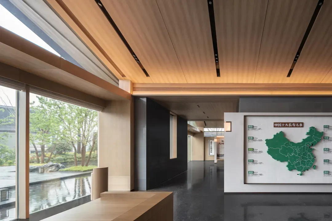 Modern office lobby with wooden features and greenery outside, focusing on a map display.