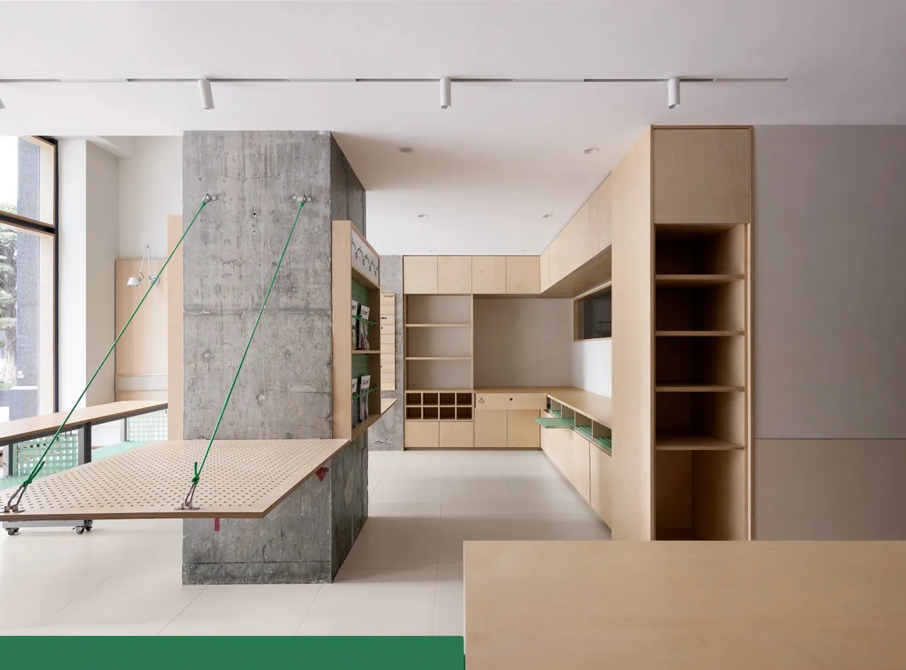 An office with concrete walls and wooden furniture, featuring a minimalist design.