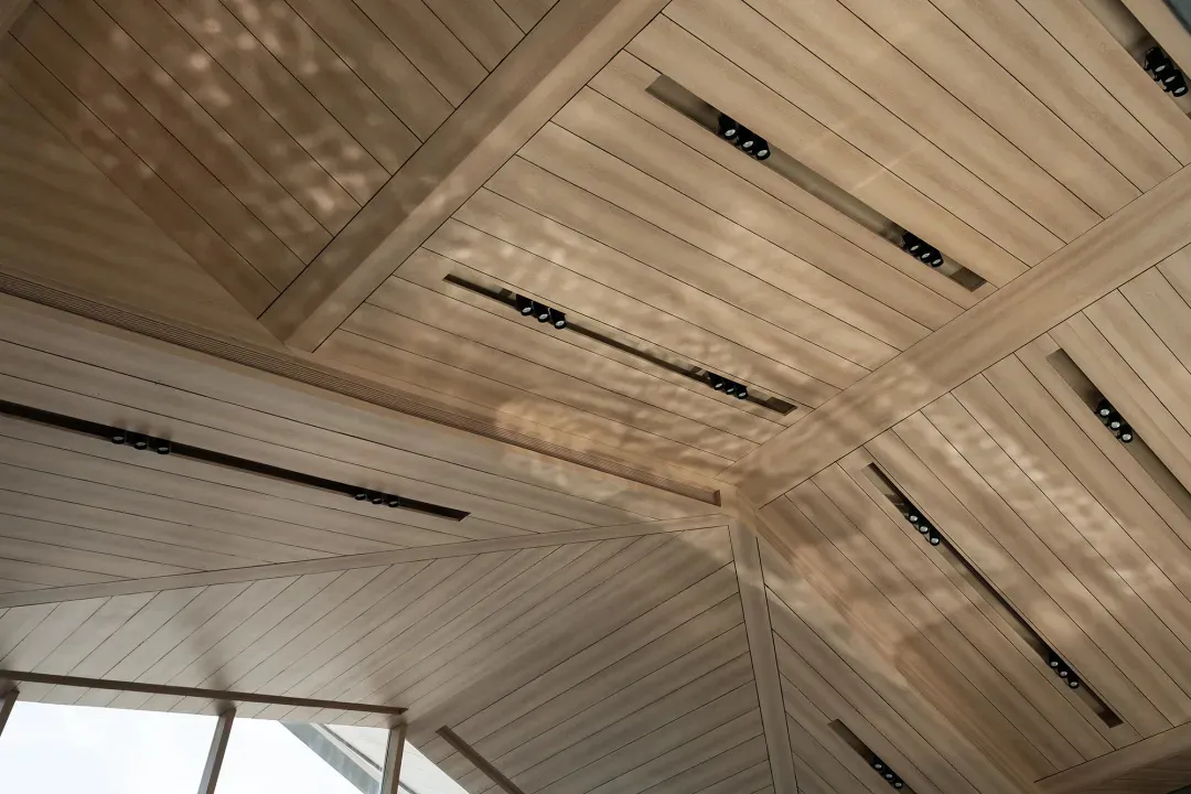 A modern ceiling with wooden paneling and integrated lighting fixtures.