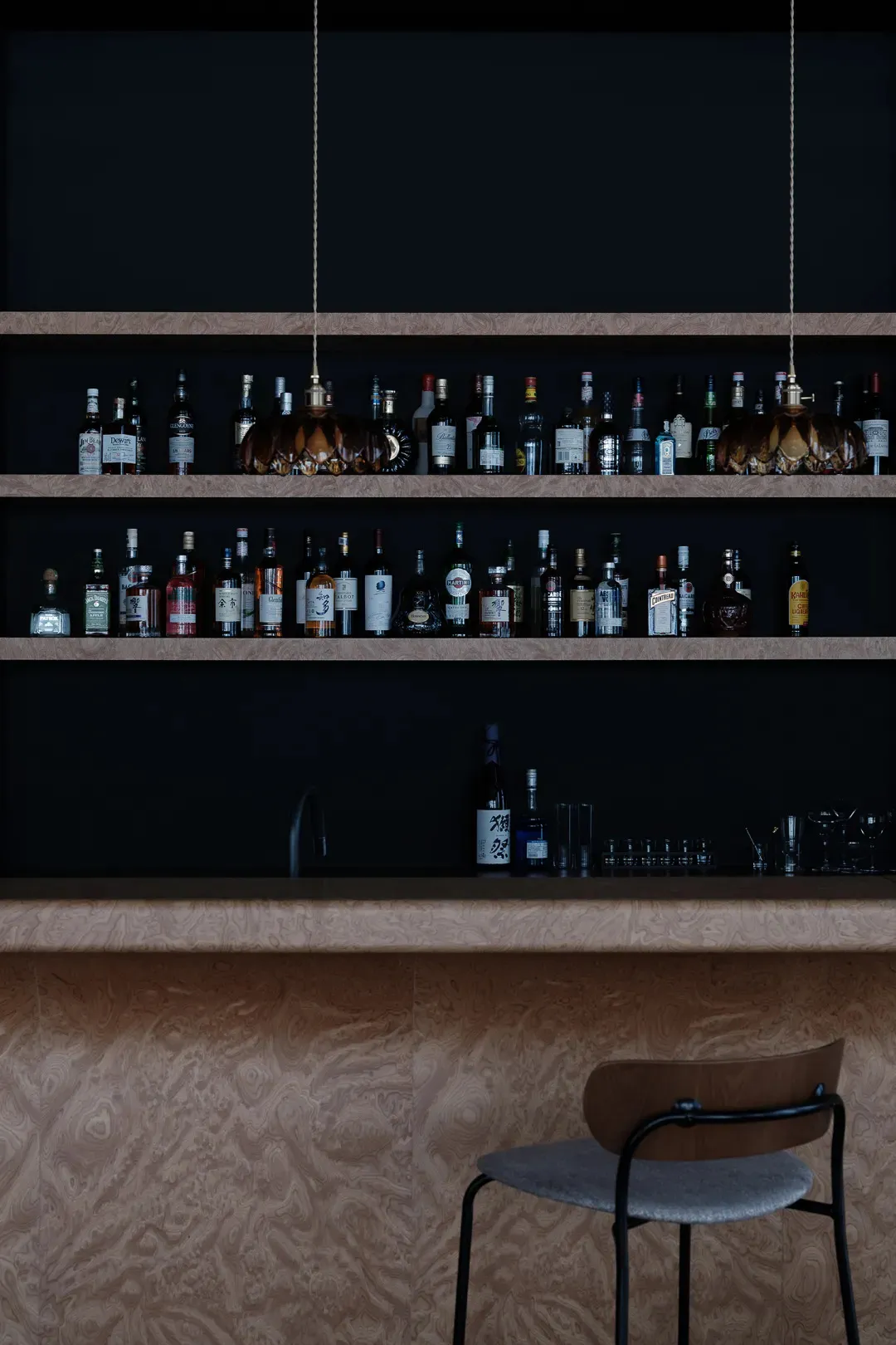 A sleek and modern bar area featuring a wooden texture and concrete finishes.