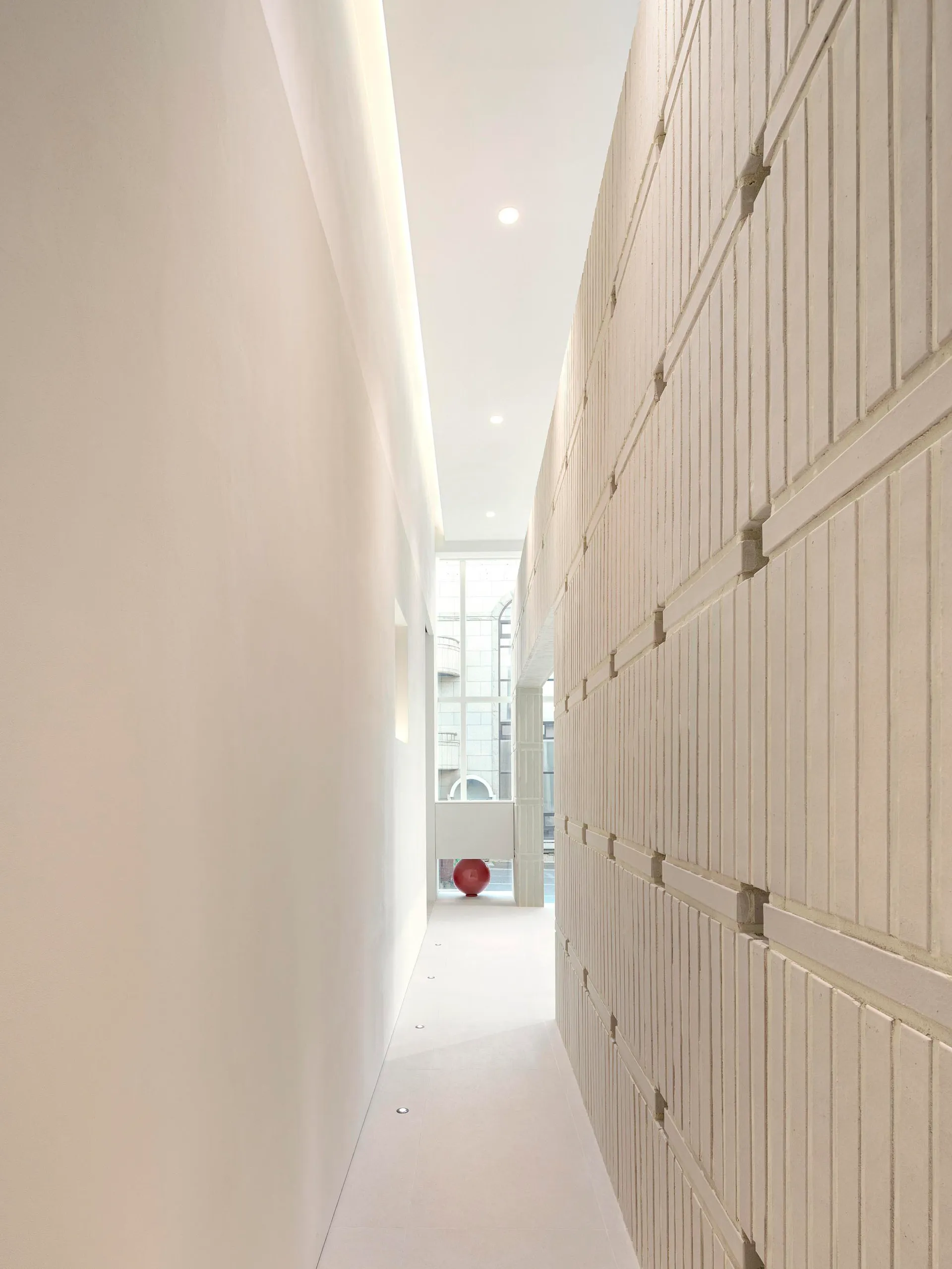 A minimalist corridor with concrete walls and floor.