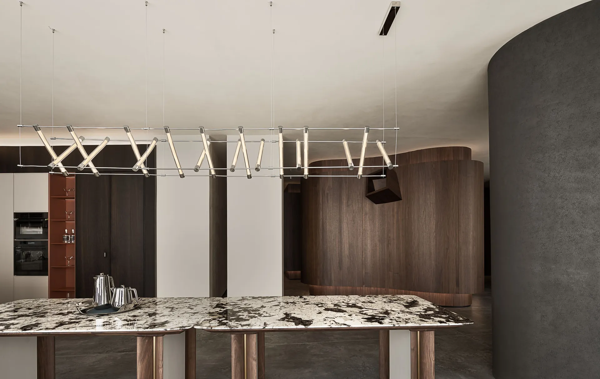 Modern minimalist dining room featuring a marble table and contemporary lighting fixture.