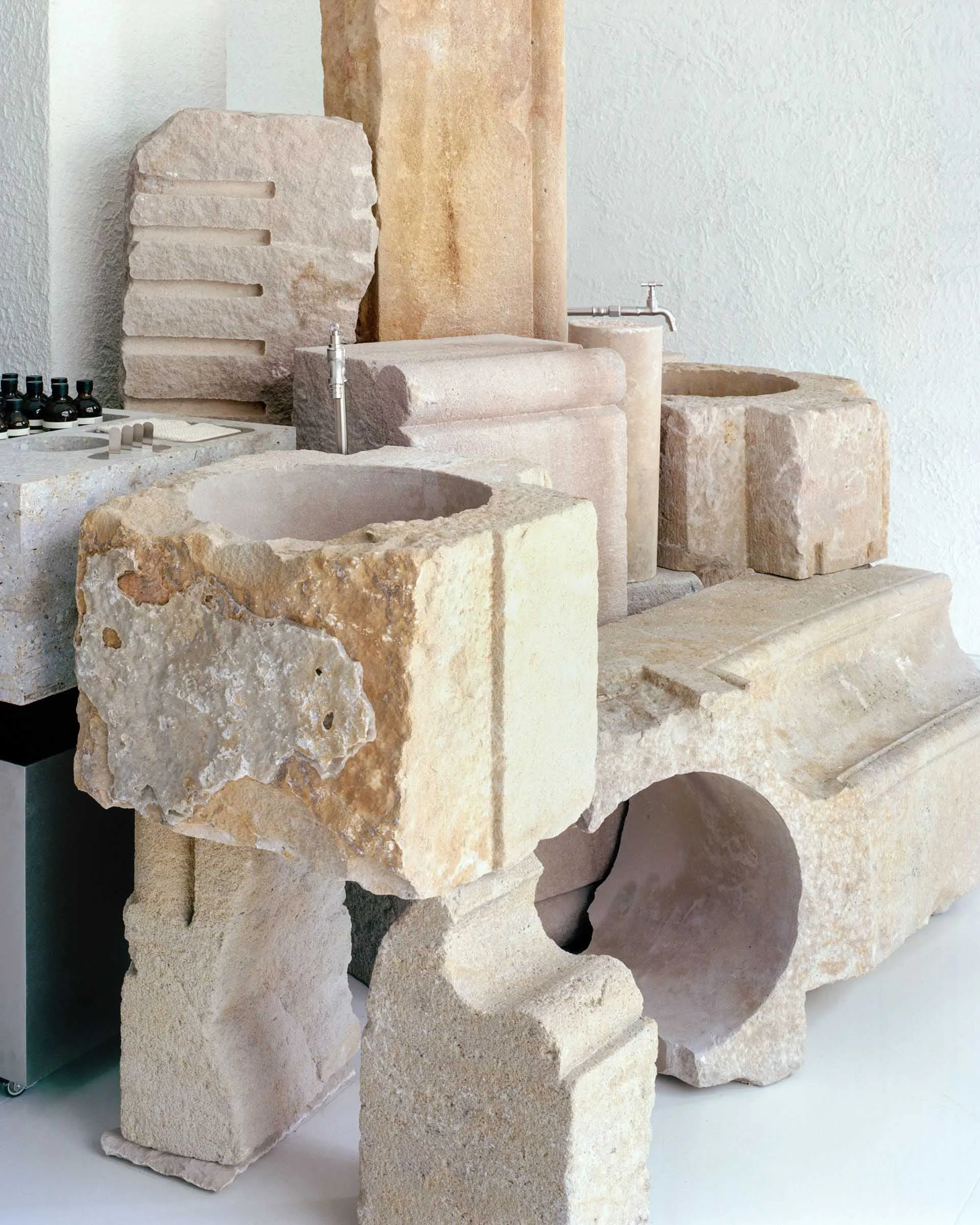 Modern bathroom featuring raw stone sinks and fixtures