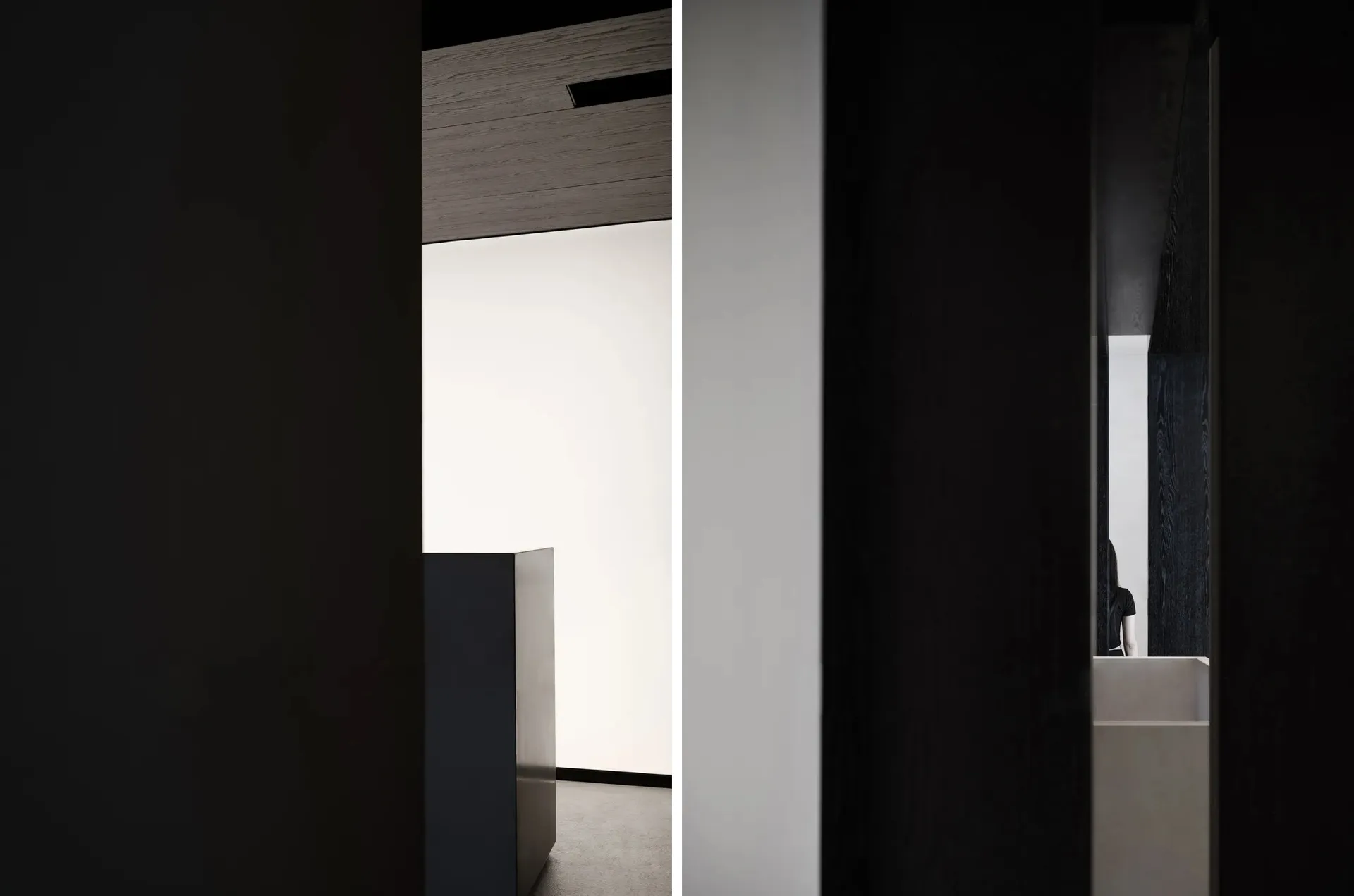 Modern minimalist interior with black walls and wooden surfaces.