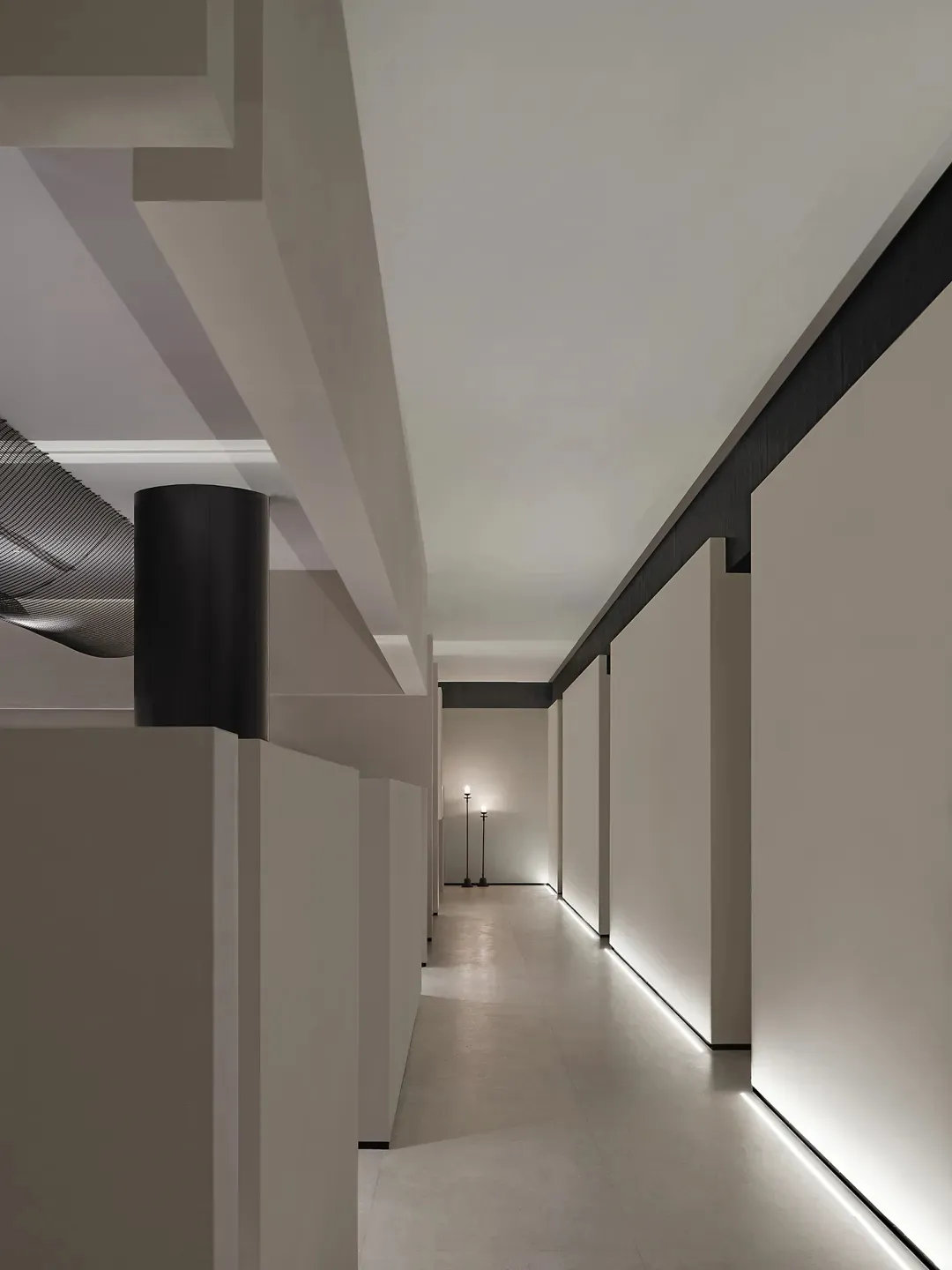 Modern interior design featuring a sleek, minimalist corridor with concrete walls and floor, illuminated by soft, ambient lig