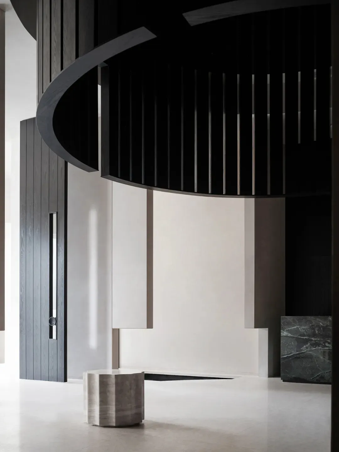 A modern lobby with a concrete floor and black and white color scheme.