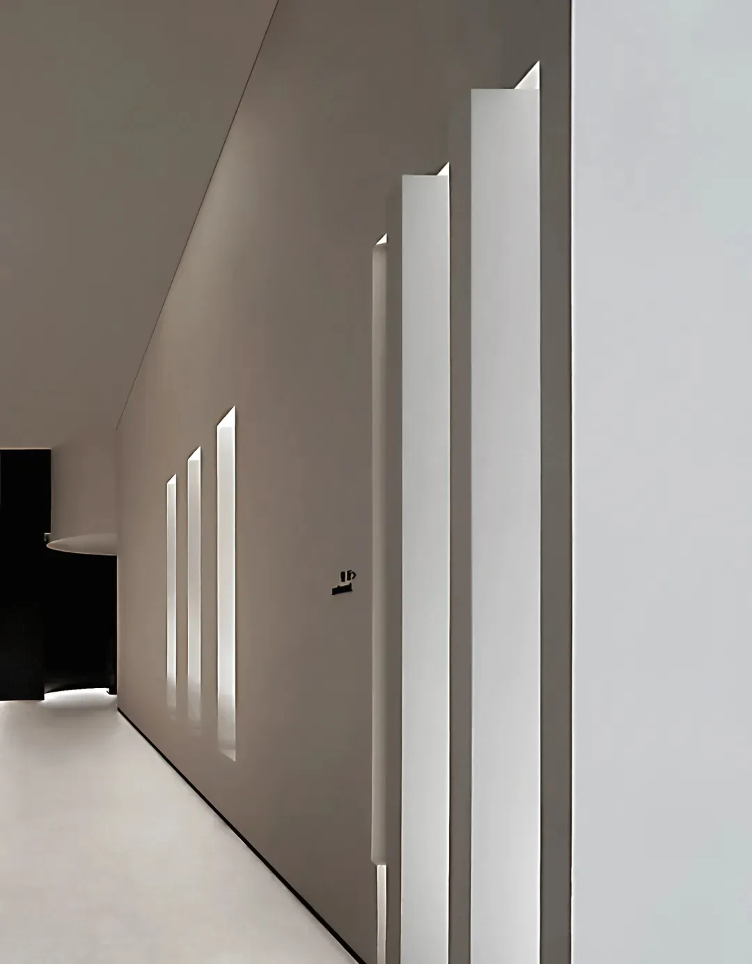 Minimalist corridor with concrete walls and floor, featuring linear design elements and geometric windows.